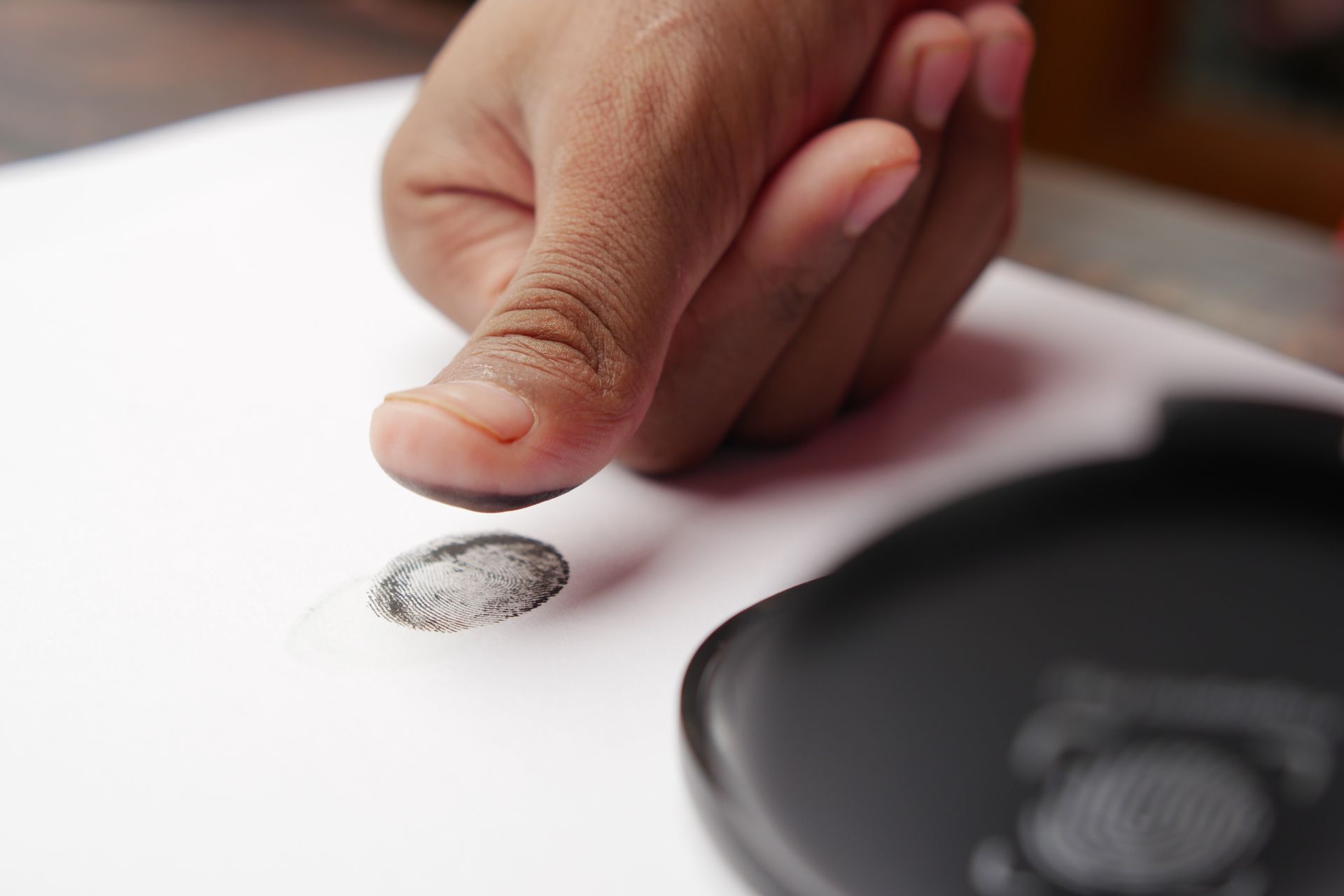 Inked thumbprint being placed on an FD-258 fingerprint card